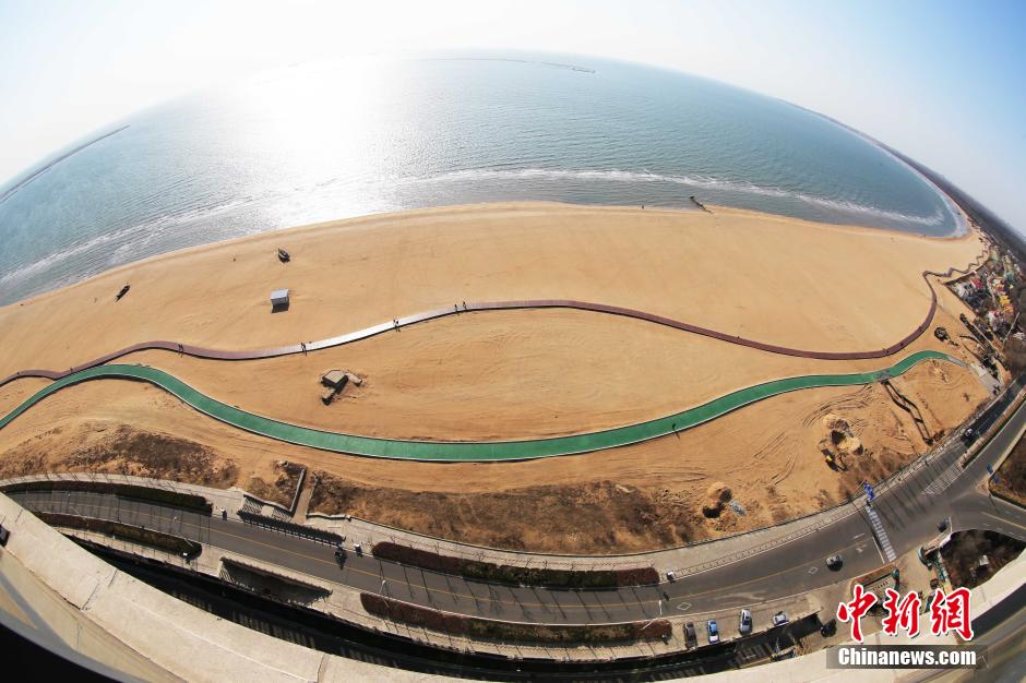 3月13日，秦皇島萬米臨海沙灘木棧道。據(jù)了解，該木棧道全長約4200米，與北戴河區(qū)原有的7500米木棧道對(duì)接后全線總長度1.17萬米，整個(gè)木棧道東起秦皇島體育基地游船碼頭，西至北戴河濕地公園，呈波浪形蜿蜒10.4公里海岸線。 中新社發(fā) 曹建雄 攝 CNSPHOTO